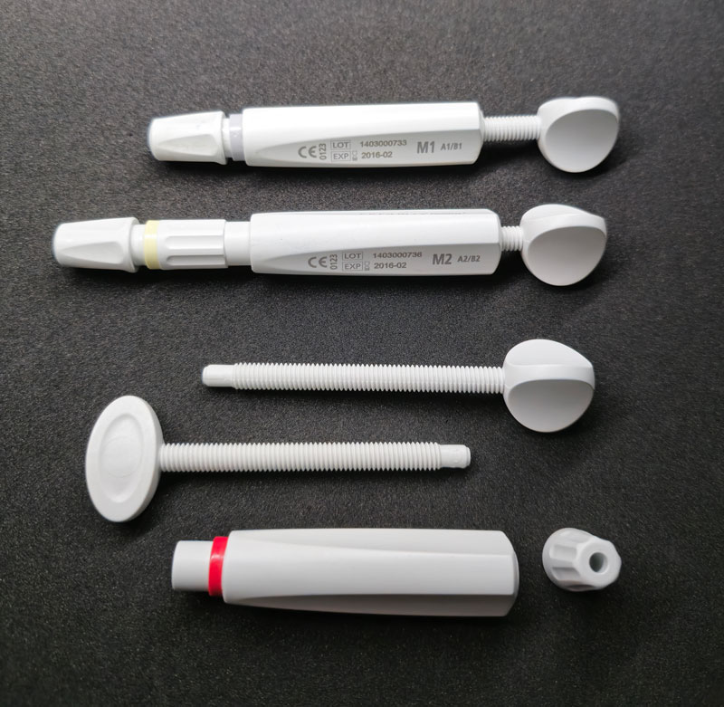 Graues Medizinisches Kunststoffteil mit präzise ausgearbeitetem Gewinde, gefertigt mittels Ausspindeltechnik. Hersteller Fertigung Produzent Leiferant Schnitzler Kunststofftechnik in Küps bei Kronach, Region Oberfranken, Bayern, Deutschland