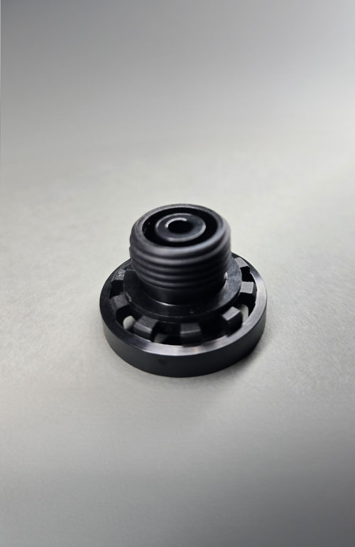 Schwarzes Kunststoffteil mit präzise ausgearbeitetem Gewinde, gefertigt mittels Ausspindeltechnik. Hersteller Fertigung Produzent Leiferant Schnitzler Kunststofftechnik in Küps bei Kronach, Region Oberfranken, Bayern, Deutschland