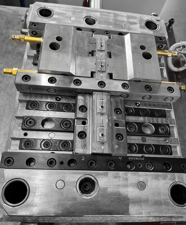 Hersteller Produzent Lieferant Firma Schnitzer Kunststoffe zeigt ein Spritzguss Werkstück für die erstellung der Kunststoffteile in Massenproduktion